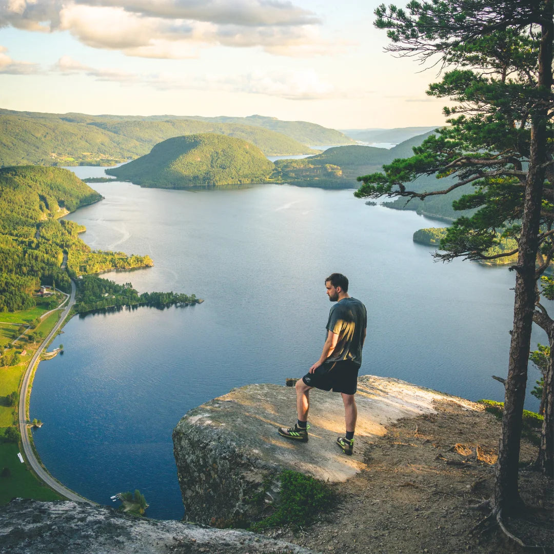 Wanderer steht auf einem Felsen über einem Fjord