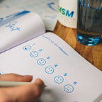 Notizbuch mit Stimmungsskala neben MSMperfect Dose und einem Glas Wasser