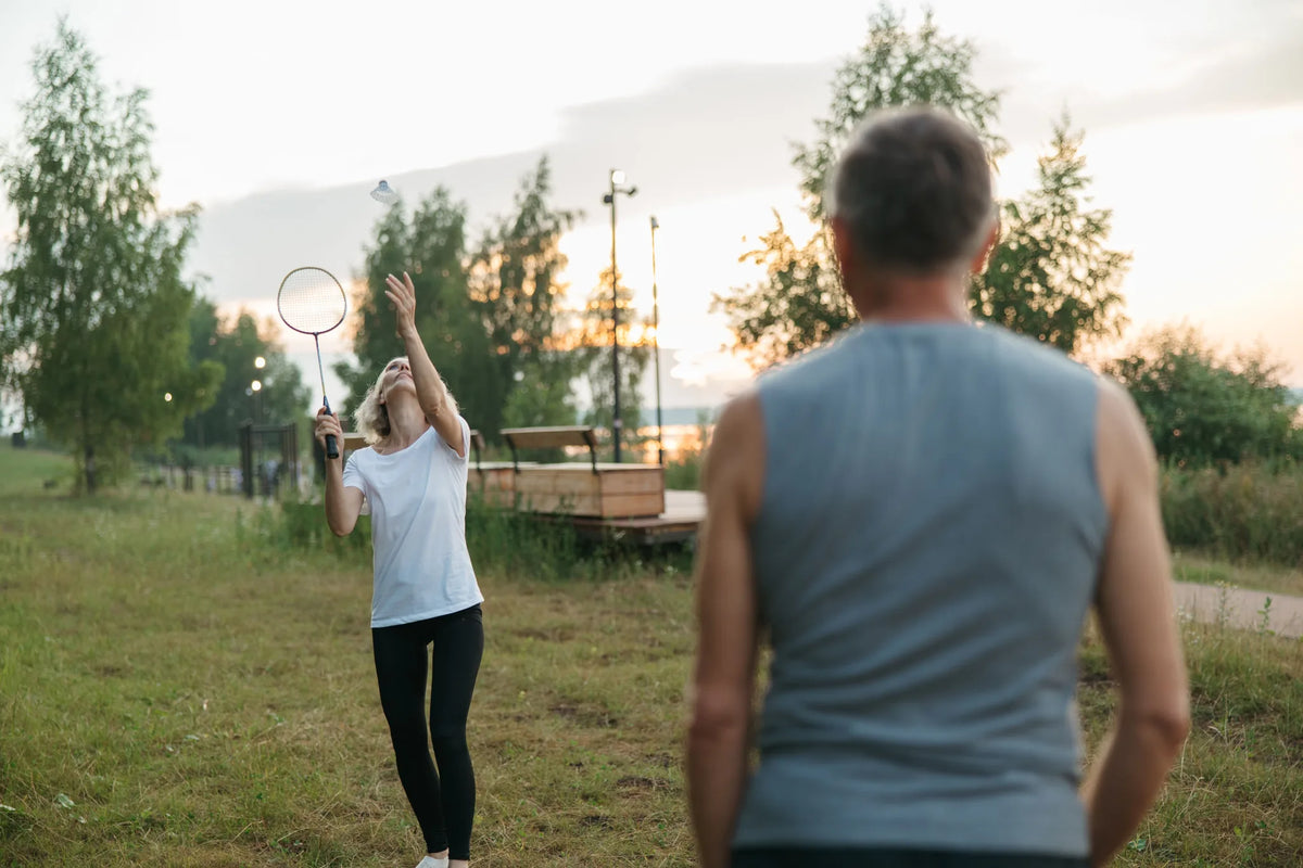 Älteres Paar spielt Federball auf einer Wiese im Park